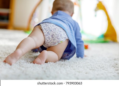 Little Cute Baby Girl Learning To Crawl. Healthy Child Crawling In Kids Room With Colorful Toys. Back View Of Baby Legs. Cute Toddler Discovering Home And Learning Different Skills.