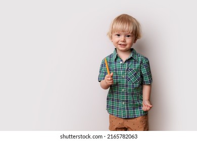 a little cute blond boy in big glasses and a green checkered shirt stands against a white wall, preschool education, kindergarten, school for talented children, nerd, elementary school, place for text