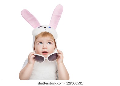 Little Cute Boy With Big Blue Eyes Dressed In Easter Bunny Ears Take Off Sunglasses And Looking Up. Little Easter Bunny On White Background.