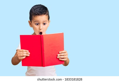 Little Cute Boy Kid Reading A Book Scared And Amazed With Open Mouth For Surprise, Disbelief Face 