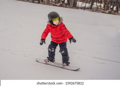 Little cute boy snowboarding. Activities for children in winter. Children's winter sport. Lifestyle
