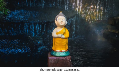 Little Cute Buddha Monk Scultpture In The Pond