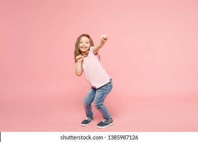 Little cute child kid baby girl 3-4 years old wearing light clothes dancing isolated on pastel pink wall background, children studio portrait. Mother's Day, love family, parenthood childhood concept