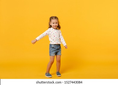 Little cute child kid baby girl 4-5 years old wearing light denim clothes isolated on pastel yellow wall background, children studio portrait. Mother's Day, love family, parenthood childhood concept