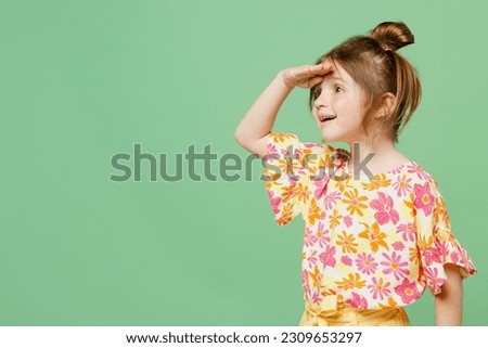 Little cute child kid girl 6-7 years old wear casual clothes have fun hold hand at forehead look far away distance isolated on plain pastel green background. Mother's Day love family lifestyle concept