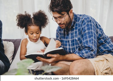 Un petit enfant mignon qui a l'air étonnant aime lire des livres et apprendre le soutien de papa au concept d'enfant intelligent.
