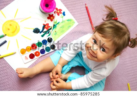 Little cute girl painting sun inside