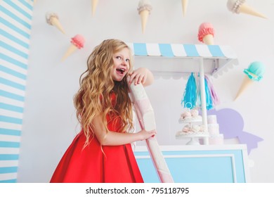 Little cute girl play with sweets in studio