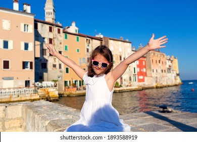 Little cute girl  posing on the embankment of Rovinj town, Croatia.