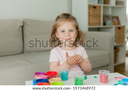 Little cute girl sculpts from colored plasticine. Development of children.