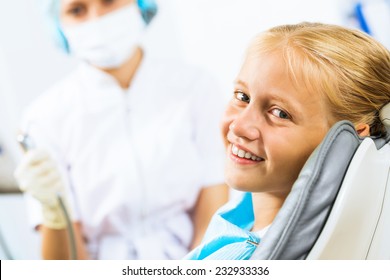 Little Cute Girl Sitting In Chair At Dentist