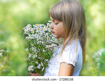 Kleines süßes Mädchen mit wilder Blume auf der Wiese, weicher Fokus