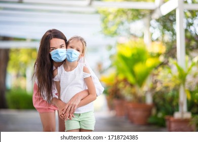 Little cute girl and young mother in medical masks at tropical beach - Powered by Shutterstock