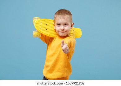Little cute kid boy 4-5 years old wearing yellow clothes hold in hand skateboard isolated on pastel blue wall background, children studio portrait. People sincere emotions childhood lifestyle concept - Shutterstock ID 1589921902