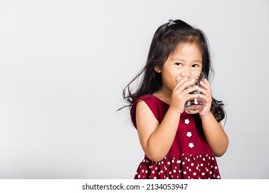 Little Cute Kid Girl 3-4 Years Old Smile Drinking Fresh Water From Glass In Studio Shot Isolated On White Background, Asian Children Preschool, Daily Life Health