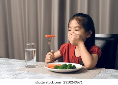 Little cute kid girl refusing to eat healthy vegetables. Children do not like to eat vegetables. - Powered by Shutterstock