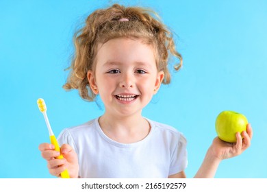 Little Cute Smiling Girl Holding Apple Toothbrush. Kid Training Oral Hygiene. Healthy Eat, Dentistry. Child Learning Brushing  Tooth, Cleaning Teeth. Prevention Of Caries Dental Care 