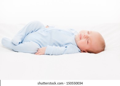 Little cute smiling newborn baby child sleeping bed white isolated