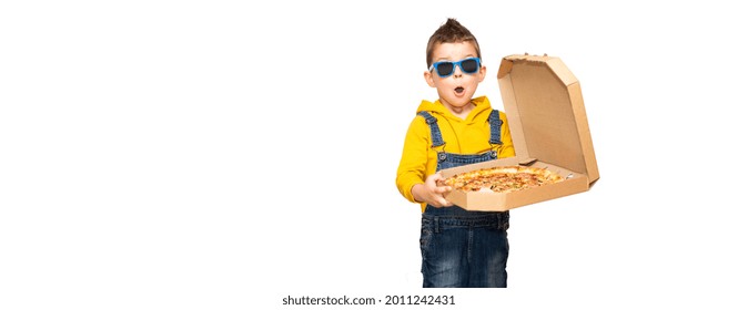 Little cute surprised baby boy in a yellow sweater and denim overalls and blue sunglasses smiles and holds an open box with pizza isolated on background.	