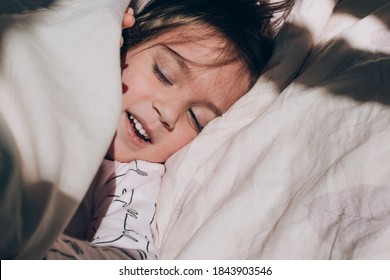 Little Cute Toddler  Girl Wake Up In The Morning Sunlight In Her Bed. Genuine Lifestyle Moments.  Happy Childhood.