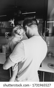 Little Daughter With Dad Indoors In The Kitchen Cooking Breakfast Meal Together. Father Hold His Daughter. Black And White Photo. Models Shot From The Back. Father's Day