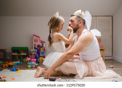 Little daughter and father have fun, dressing in princess costume, daddy makeup - Powered by Shutterstock