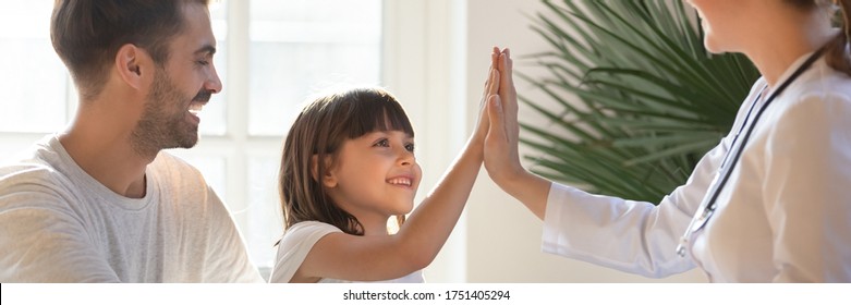 Little daughter gives high five to female doctor, pediatrician greets small kid girl patient, child healthcare medical check up, friendly relation concept. Horizontal banner for website header design