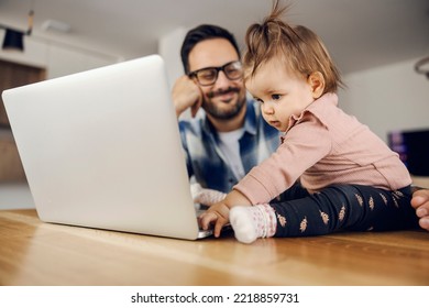 A Little Daughter Helping Her Busy Dad With Freelance Work From Home On A Laptop.