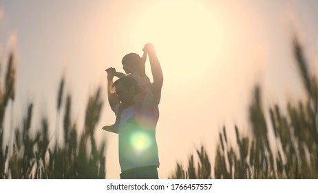 Little Daughter On Father's Shoulders. Baby Boy And Dad Travel On A Wheat Field. Child And Parent Play In Nature. Happy Family And Childhood Concept. Slow Motion