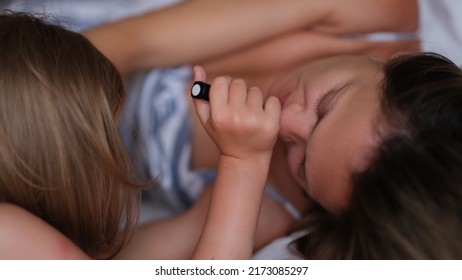 Little Daughter Paints Lips With Lipstick For Mom