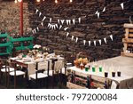 Little dinner table served in rustic style and decorated with pink flowers stands outside