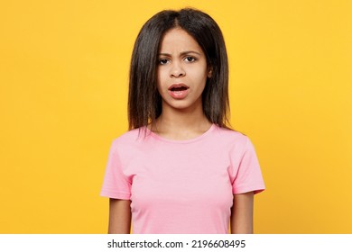 Little Disappointed Sad Worried Kid Girl Of African American Ethnicity 12-13 Years Old Wear Pink T-shirt Look Camera Isolated On Plain Yellow Background Studio Portrait. Childhood Lifestyle Concept