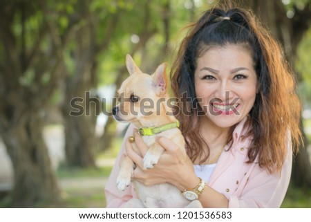 Little dog with beautiful asian woman  spend a day at the park playing and having fun.Soft focus