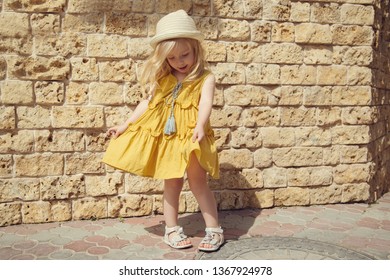 Little Emotion Beautiful Blonde Smiling Girl Poses. Copy Space. Bright Summer Street Photos Of A Little Fashionista.