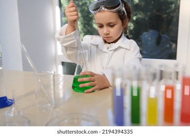 Little European preschooler girl making scientific experiments, fascinated and inspired by learning Chemistry. Science, chemical education concept. Back to school in the new academic year semester - Powered by Shutterstock