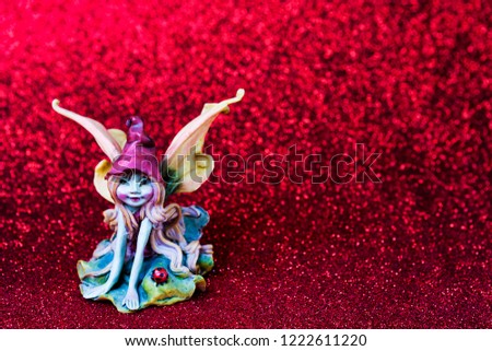 Little fantasy fairy with ladybug on red glittering background