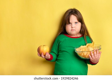 Little fat girl who chooses between apples and chips