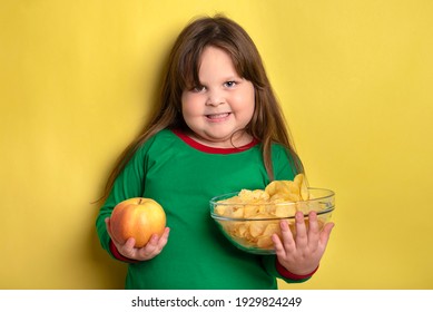 Little fat girl who chooses between apples and chips