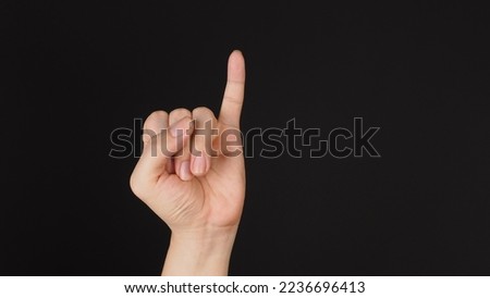 Little finger or pinkie gesture hand sign on black background.