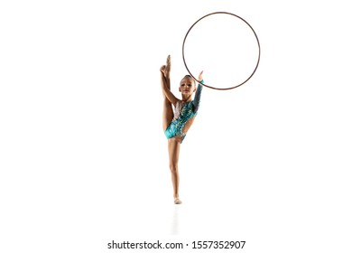 Little flexible girl isolated on white studio background. Little female model as a rhythmic gymnastics artist in bright leotard. Grace in motion, action and sport. Doing exercises with the hoop. - Powered by Shutterstock