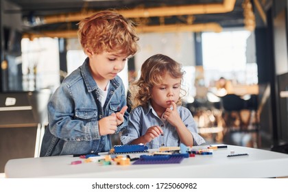 Little Friends Have Fun With Construction Toys In Playroom. Kindergarten Educational Games.