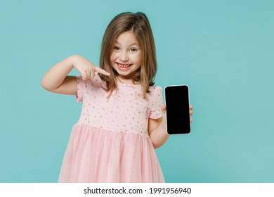 Niña pequeña y divertida, linda niña de 5 a 6 años, usa un vestido rosa en la mano usando un teléfono celular aislado en un retrato de estudio infantil de color azul pastel. El concepto del estilo de vida familiar del Día de la Madre