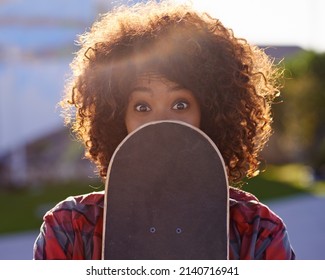 A Little Fun In The Skate Park. A Young Woman With A Quirky Expression Holding Her Skateboard.