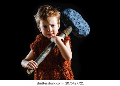 Little funny angry warrior boy is a Neanderthal or a Cro-Magnon. Ancient caveman with huge ax isolated on black,  black.