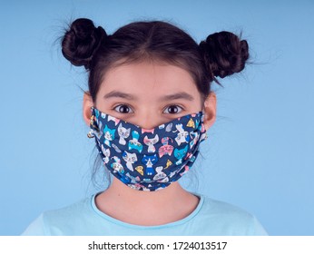 Little funny girl with a collorful mask. Excitement and fascination concept. Close up portrait. Coronavirus blue background. foolish grimaces comical crazy gesture. Funny expression. Covid-19.  - Shutterstock ID 1724013517