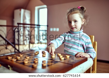 Similar – lifestyle shot of smart kid girl playing checkers at home