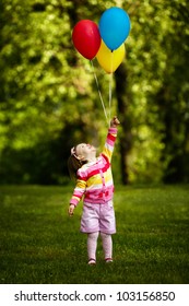 little funny girl plays with balloons in park