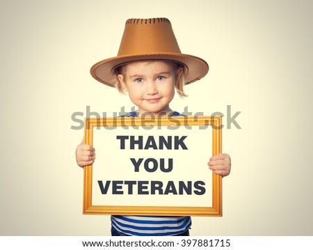 Little Funny girl in striped shirt with blackboard. Text THANK YOU VETERANS. Isolated on gray background.