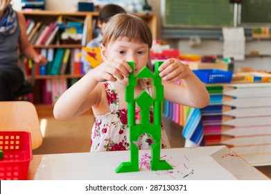 Little girl of 5 years old building a structure in a classroom
