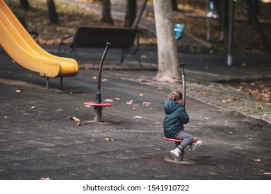 Little Girl Alone In A Playground On A Sunny Autumn Day